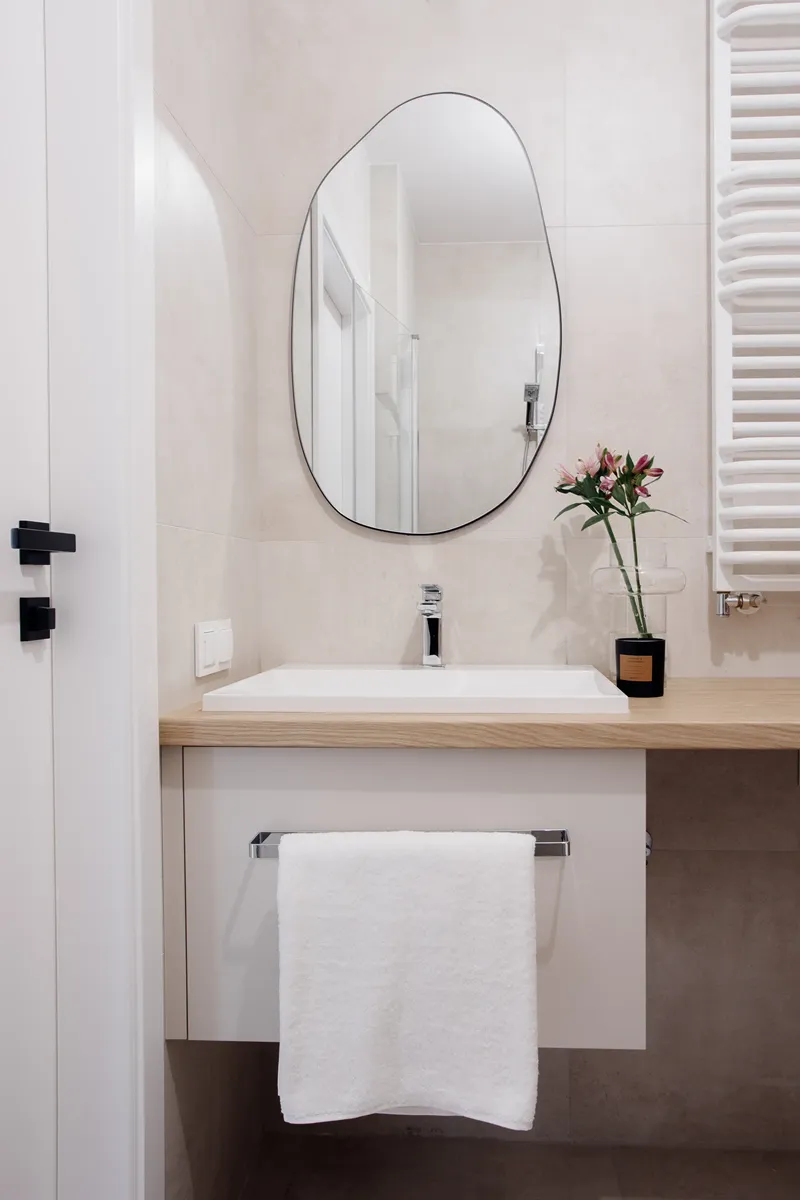 Łazienka z nieregularnym lustrem